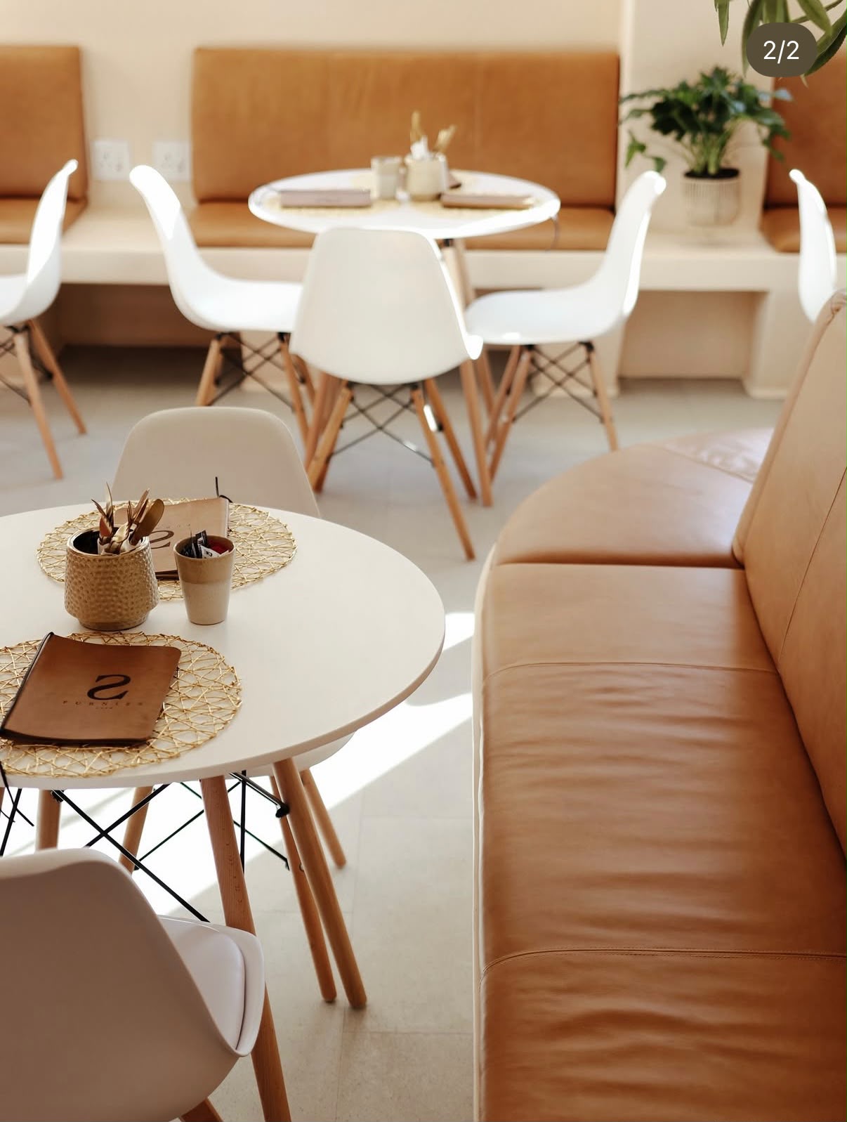 White Eames chairs and tan leather banquette at FIVE